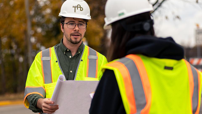 Civil engineering student at co-op site in hard hat and vest