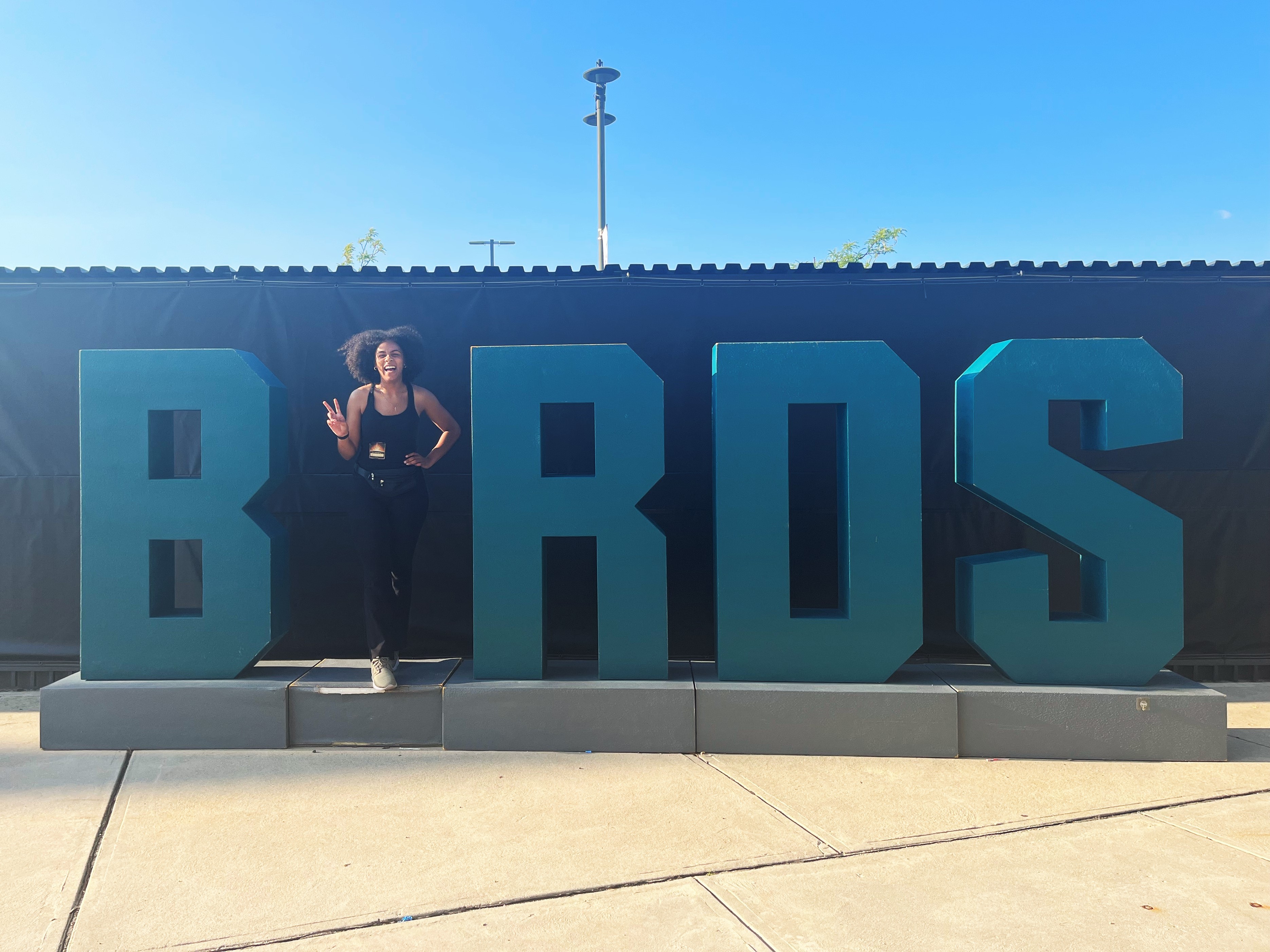Student Donya Moore stands in front of a large green Birds sign