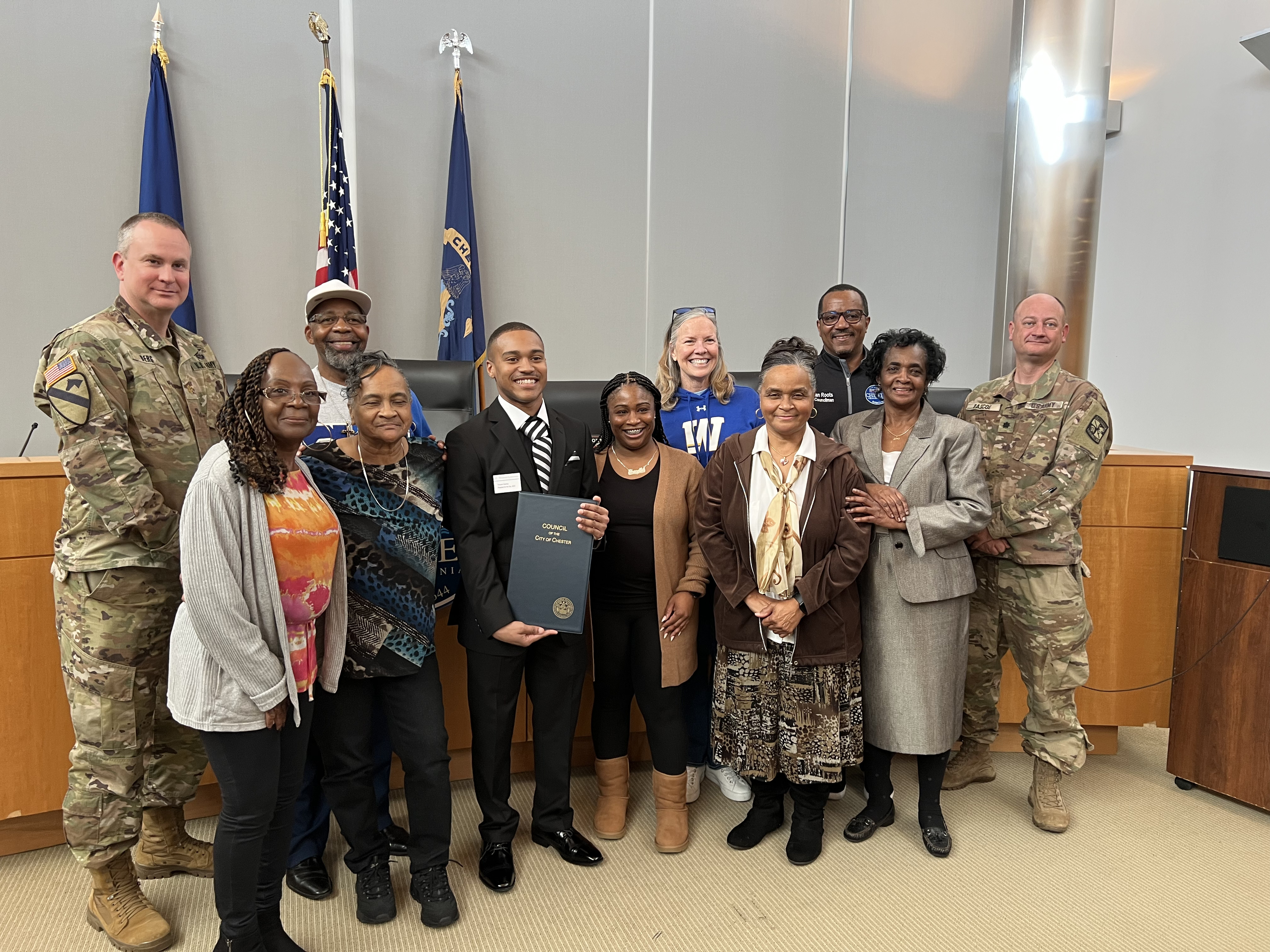 Vincent Starkey and Stacey Robertson pose with Vincent's family, Chester Mayor Thaddeus Kirkland, and Lt. Matthew Berg in City Hall.