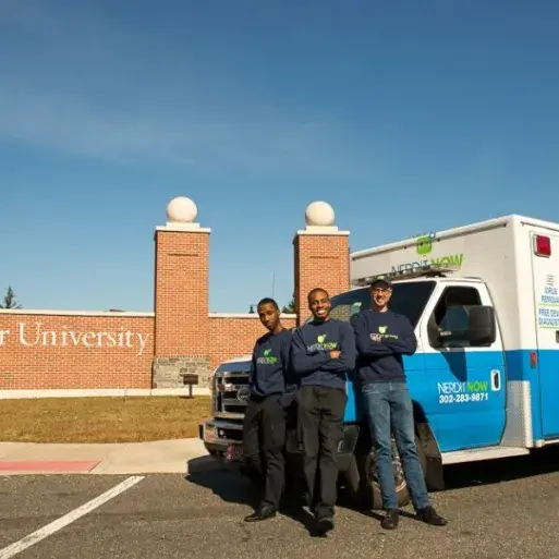 Markevis Gideon and business partners in front of Widener sign