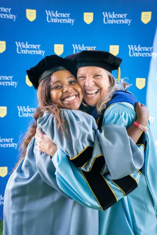 President Stacey Robertson and student trustee Ijjae Hill in a hug.