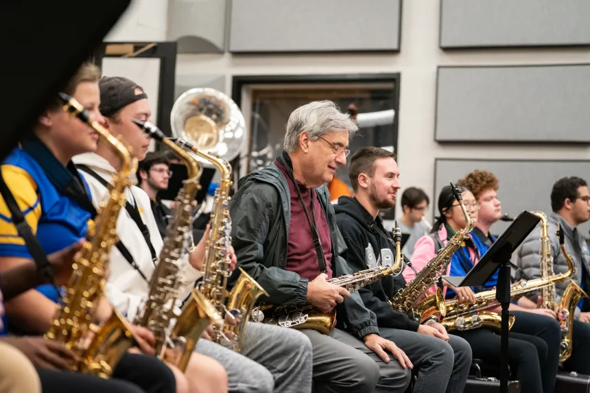 Alumni members of the band playing during a rehearsal