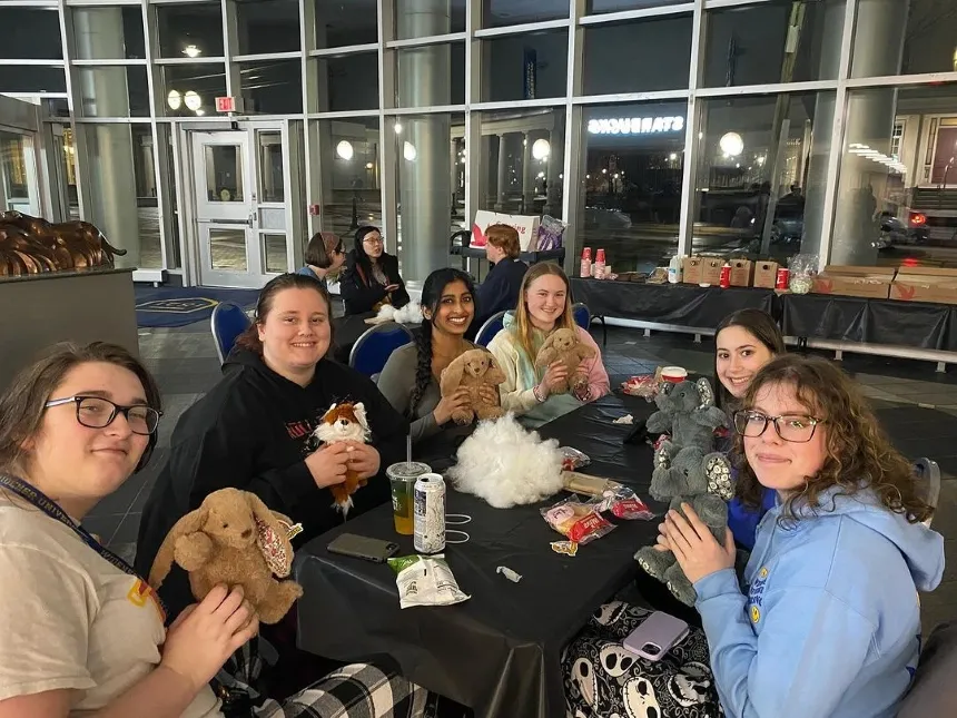 Students at the Stuff-a-Plush event hold up their creations