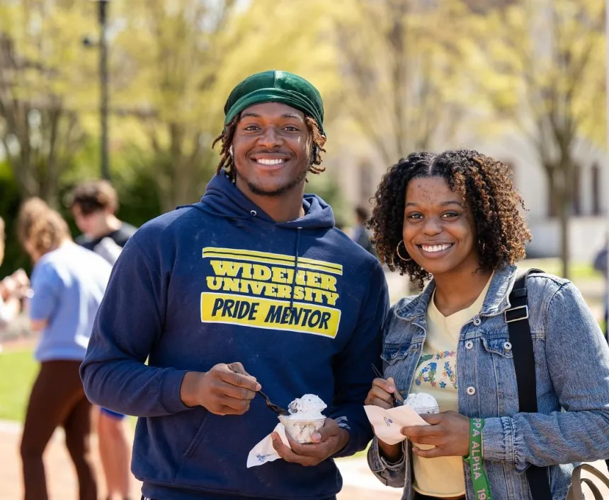 Two students holding cups of ice cream at an event at the Bown Garden