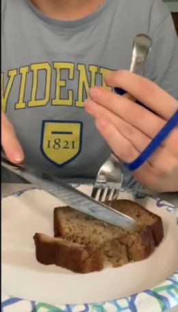 A user practices with the Spork device to hold a folk while cutting.