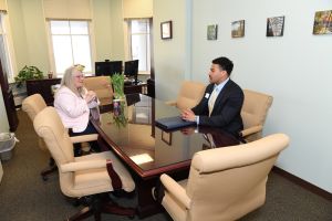 Vice President Linda Gilbert across the table from student Willie Mathis, in conversation