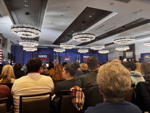 A crowd is seated facing a stage
