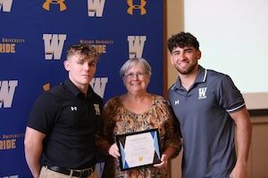 Widener student-athletes pose with professor at Athletics Faculty Advisor Program luncheon