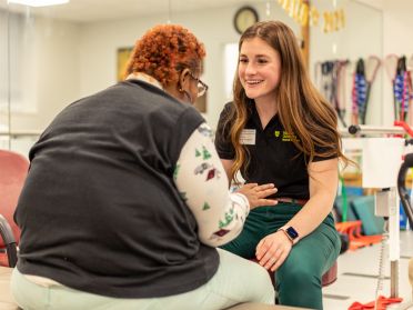 A graduate physical therapy student works with a client