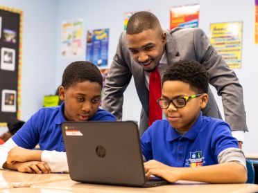 Michael Dixon working with students at a laptop