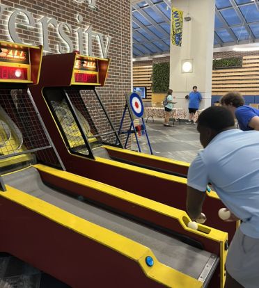Students play skee-ball in the University Center Atrium