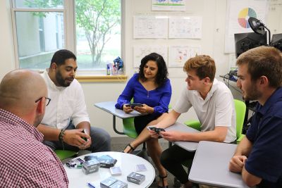 Terrance Harden and SBDC staff and students look at cards he created for his small business