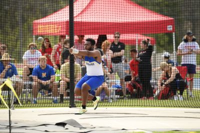 Track and field athlete Conrad Howell, in Widener uniform, throwing a weight in competition