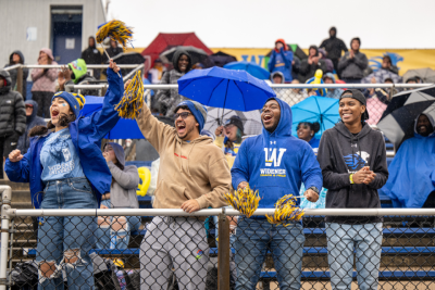 Students wearing Widener gear cheering in the stands