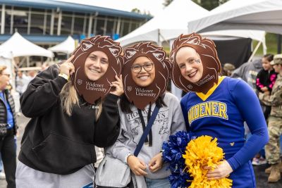 Widener students at homecoming tailgate wearing foam lion manes. 