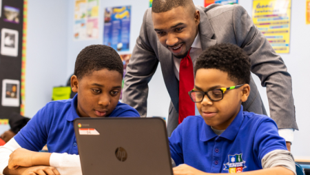 Michael Dixon working with students at a laptop.