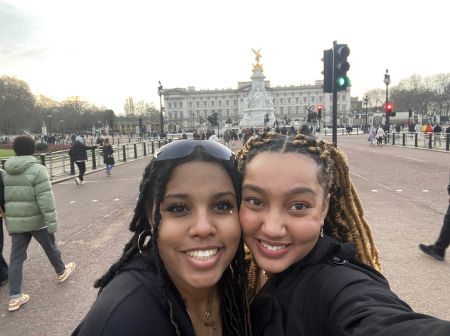 Two students take a selfie in front of Buckingham Palace