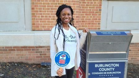A student standing next to a poll box