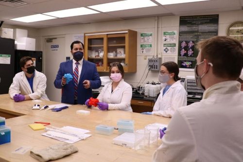 Professor Patil and students sit and work in the NanoBio Lab.