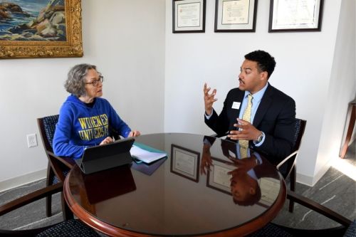 President Wollman seated next two student Willie Mathis in conversation