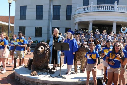 Convocation 2022 Pride Statue Stacey Robertson 960 x 640 President Robertson stands at the Pride statue in regalia with student leaders during the 2022 academic convocation.