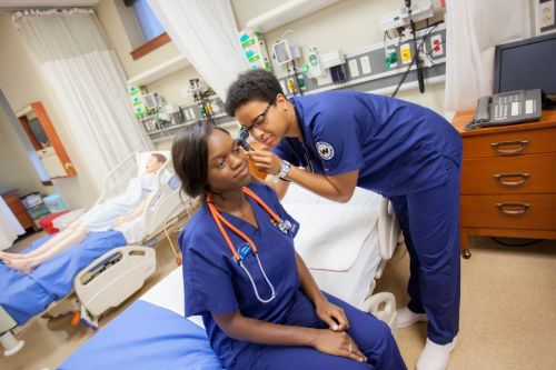 Two nursing students doing a physical exam in the nursing simulation lab