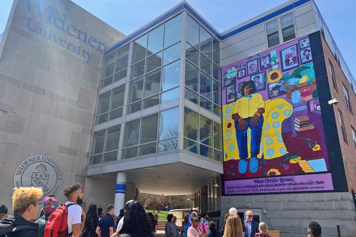 People gathered in front of Metro Hall for the ribbon cutting of a new mural on the building wall