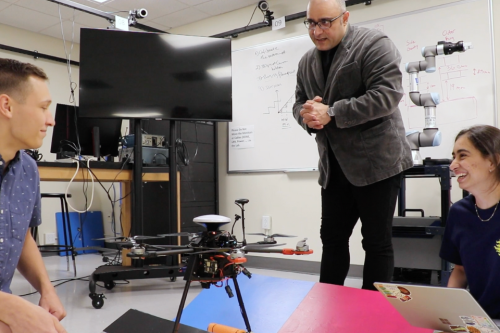 Daniel Roozbahani, Ethan Matlack, and Dimple Gandevia work with their drone on the landing pad