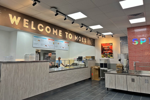 new moes 960x640 The newly renovated Moe's counter with "Welcome to Moe's" across the top and workers behind the counter setting up