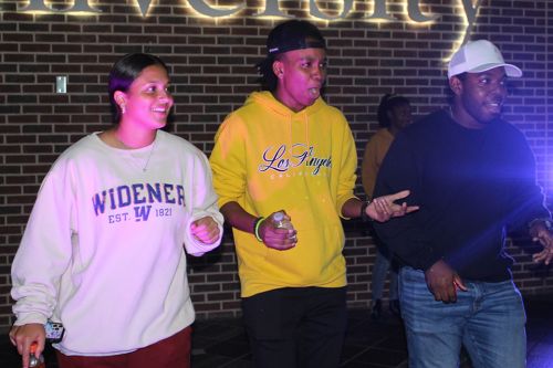 Three students dancing in the University Center Atrium