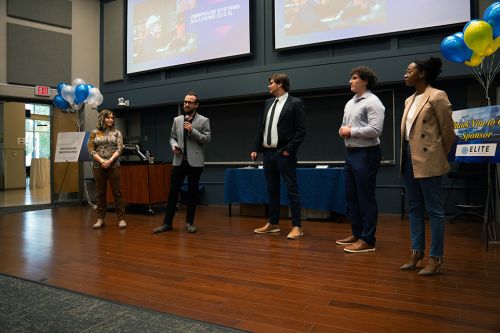 Students present in front of two powerpoint screens