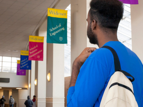Student walks through Widener's University Center with backpack.