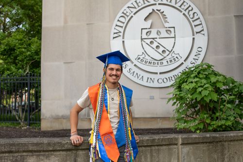 Leo Paul 960x640 Leo-Paul Wahl poses on campus in his graduation cap and his regalia cords.