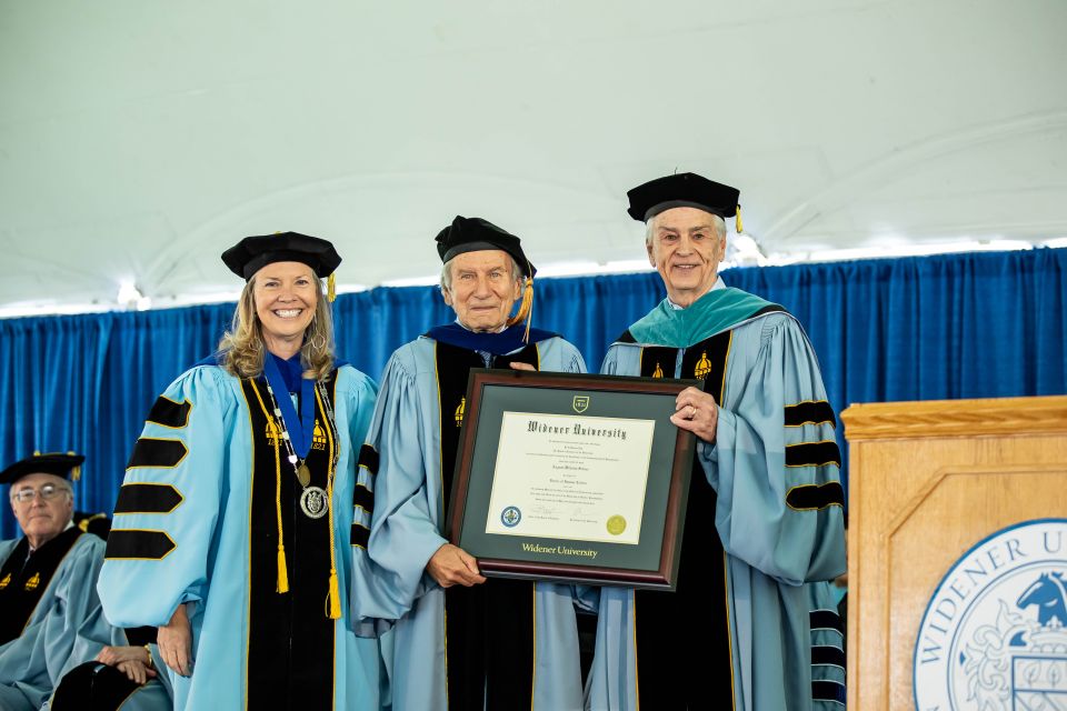 August-Wilhelm Scheer stands with President Robertson and Board Chair Paul Beideman, holding his honorary degree